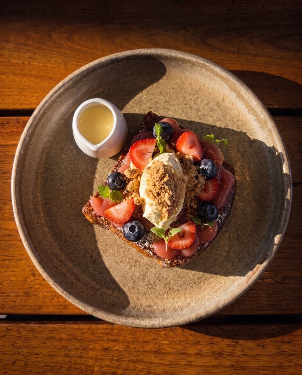French toast with berries and cream on a timber table at Tucker