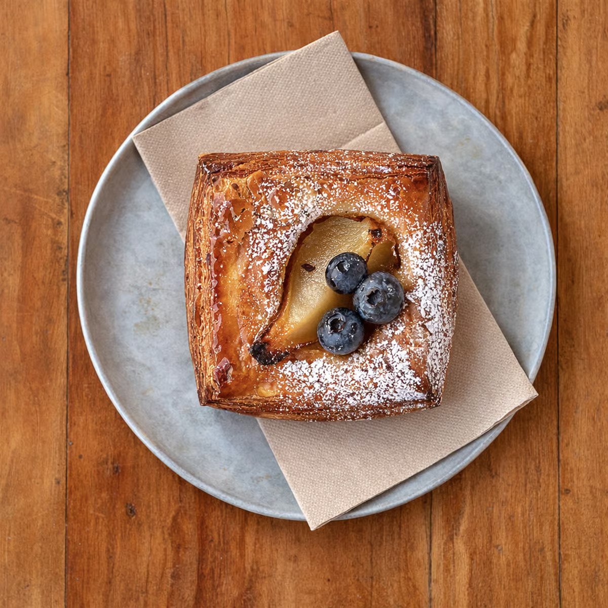 Pear and blueberry danish on a grey plate